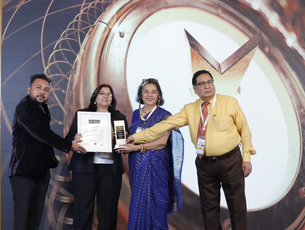 Dr. Mohini Soni receiving a recognition award on stage