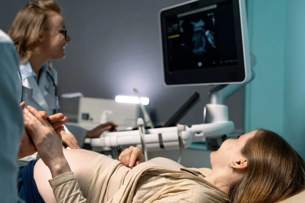 Doctor performing an ultrasound scan on a pregnant patient